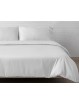 Juego de funda nórdica de seda de bambú Nature montando en la cama con zoom en color blanco