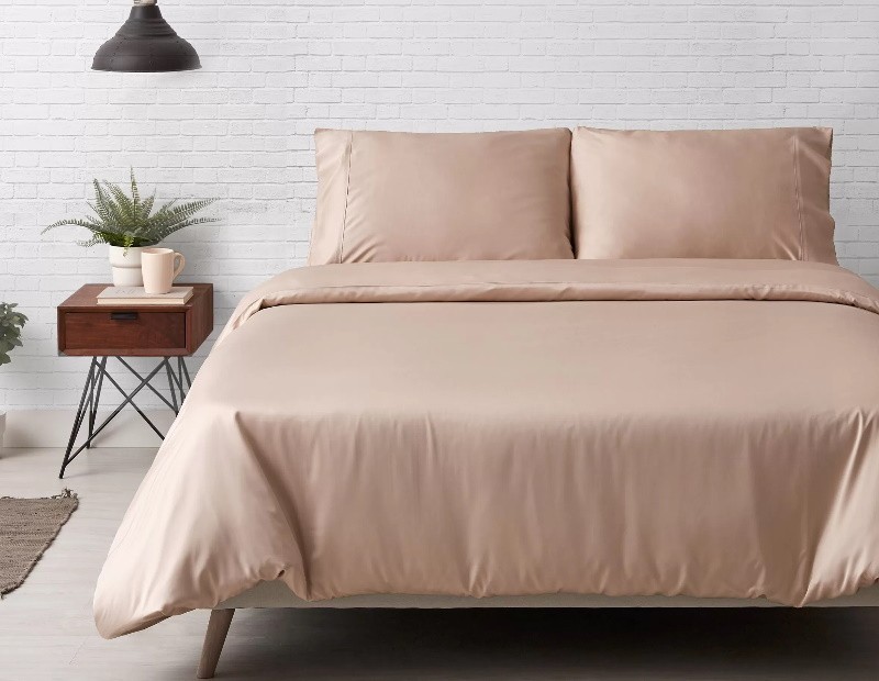 Juego de funda nórdica de seda de bambú Nature montando en la cama en color beige