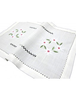 Tapete de hilo bordado con flor navideña en color blanco con detalles rojos y verdes.
